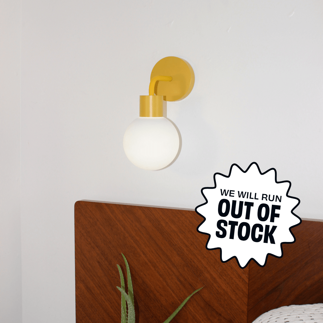 Marigold Poplight rechargeable sconce positioned above a modern wooden headboard with a promotional badge &