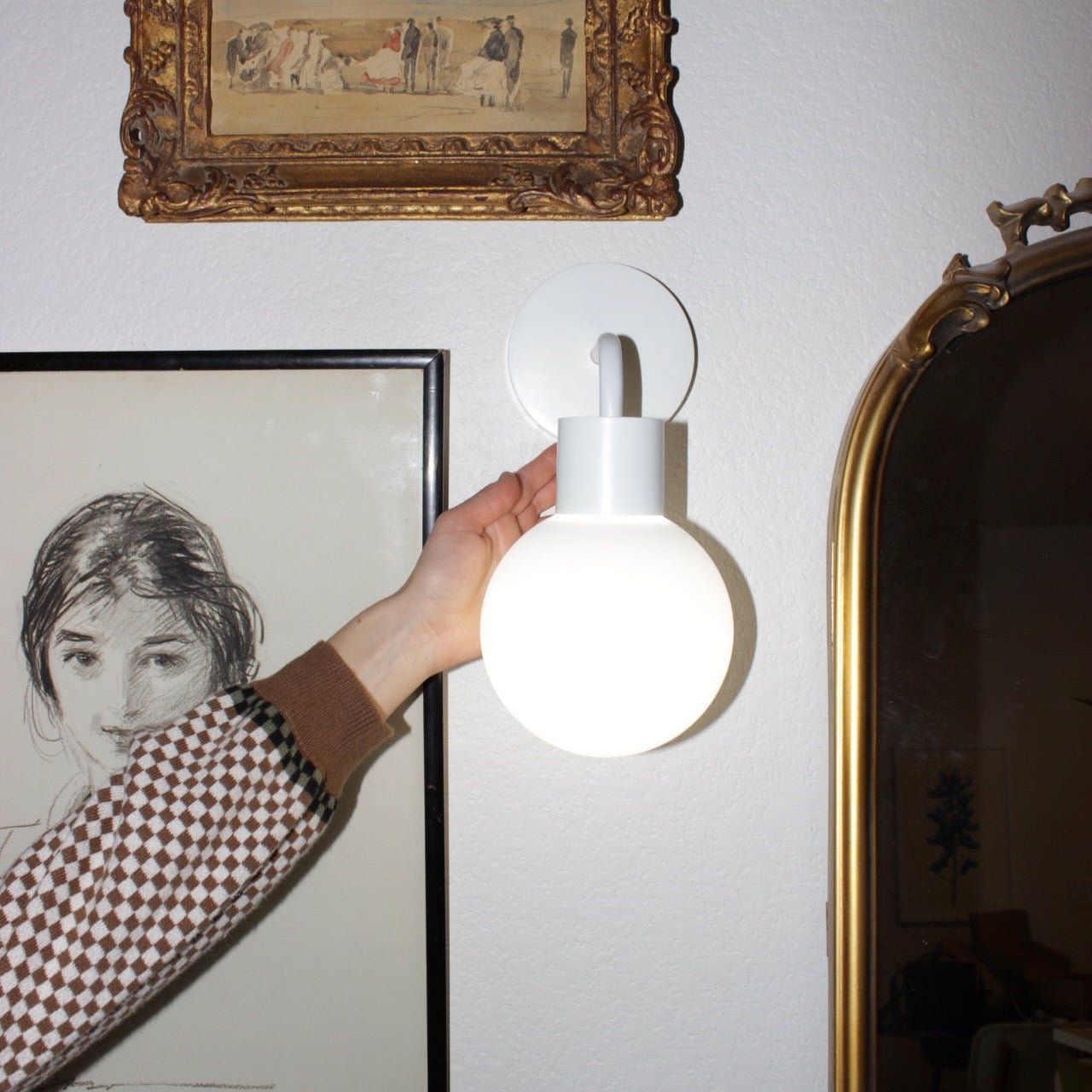 Stick-on wall sconce iin white that enhances the wall decor into chic and modern design