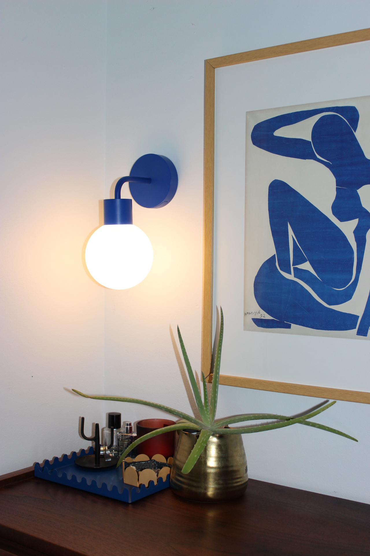 The Blue Poplight stick-on wall sconce enhances this side table corner in a warm, inviting glow—effortless elegance with no wiring needed.