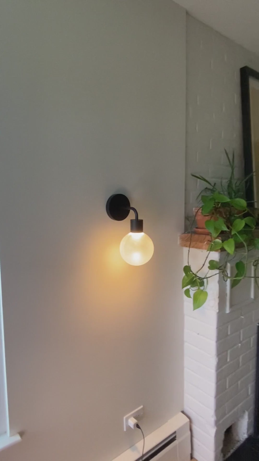 Matte black Poplight with plants illuminating the hallway