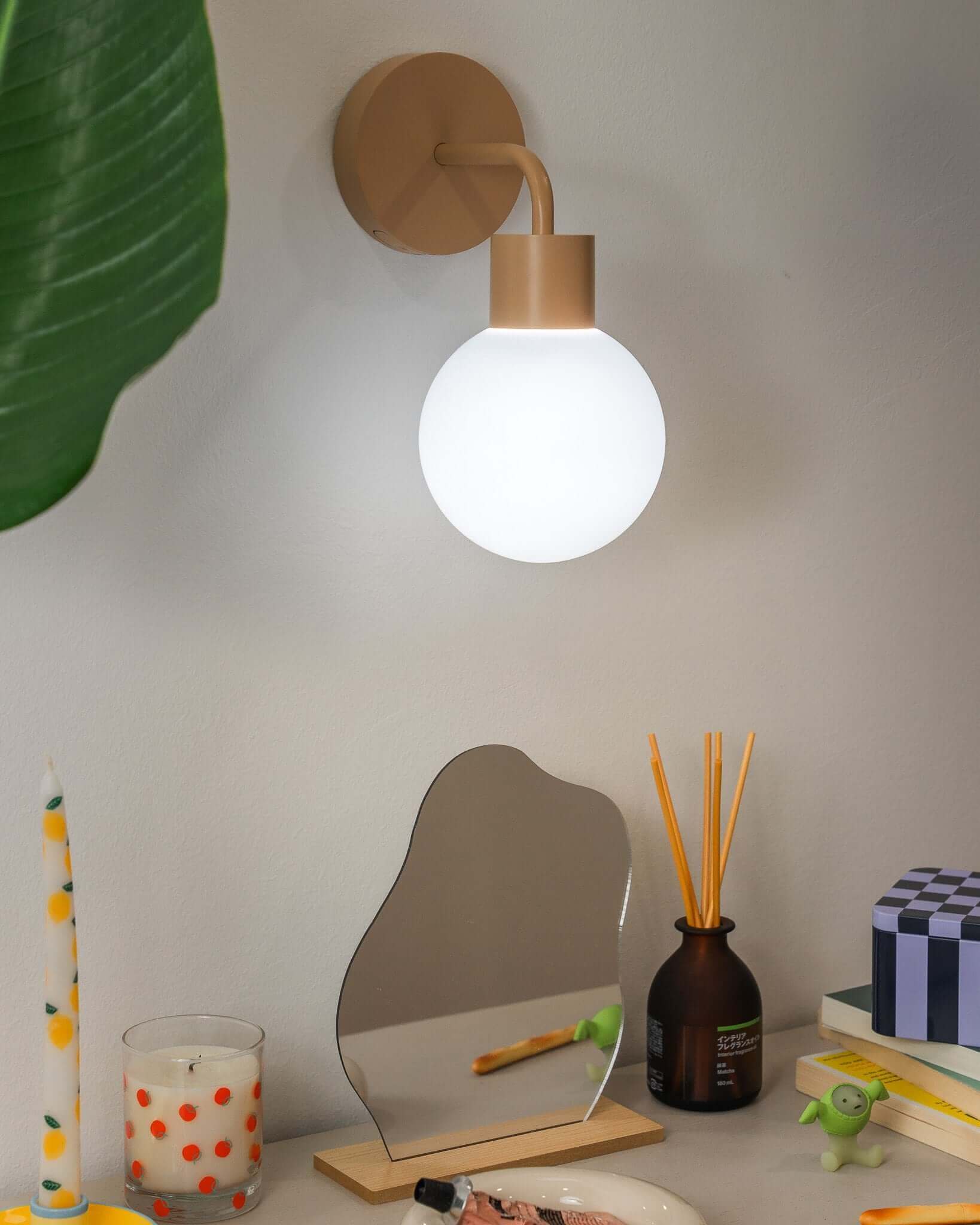 rechargeable wall sconce as wall accent to side table with mirror and leaf