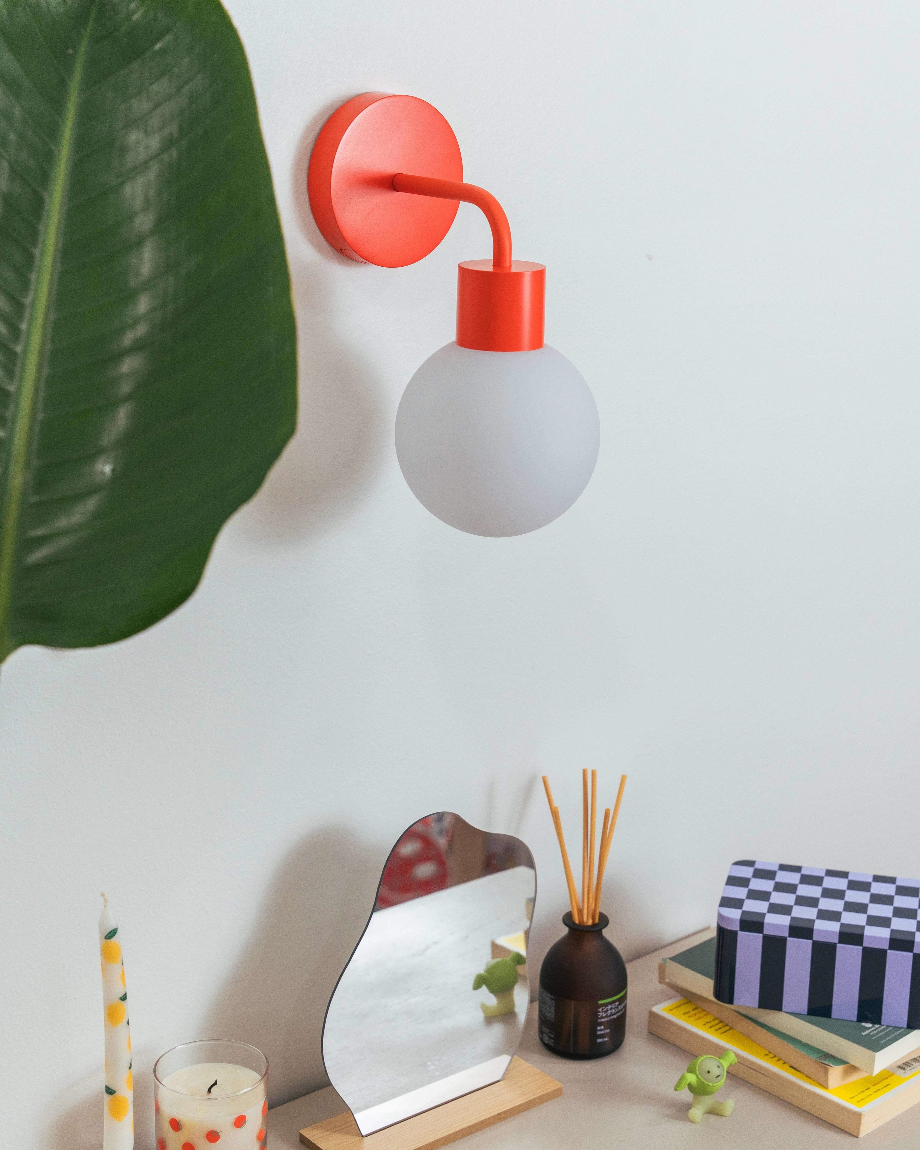 Renter-friendly rechargeable wall sconce with round globe design in a modern interior setting.