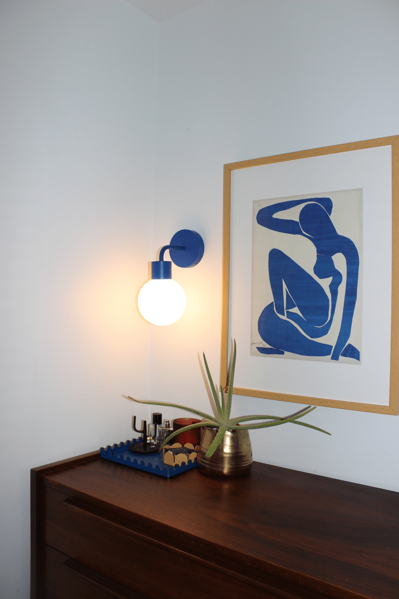 Blue rechargeable wall light installed beside a blue portrait