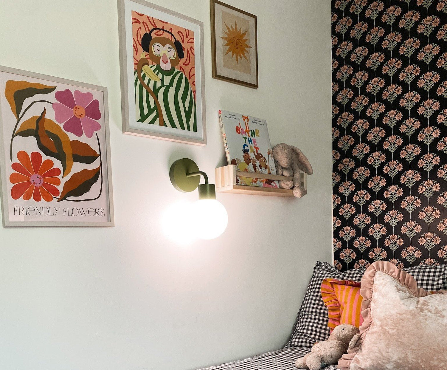 Kids bedroom decorated with kid-friendly artwork illuminated with a rechargeable wall light sconce.