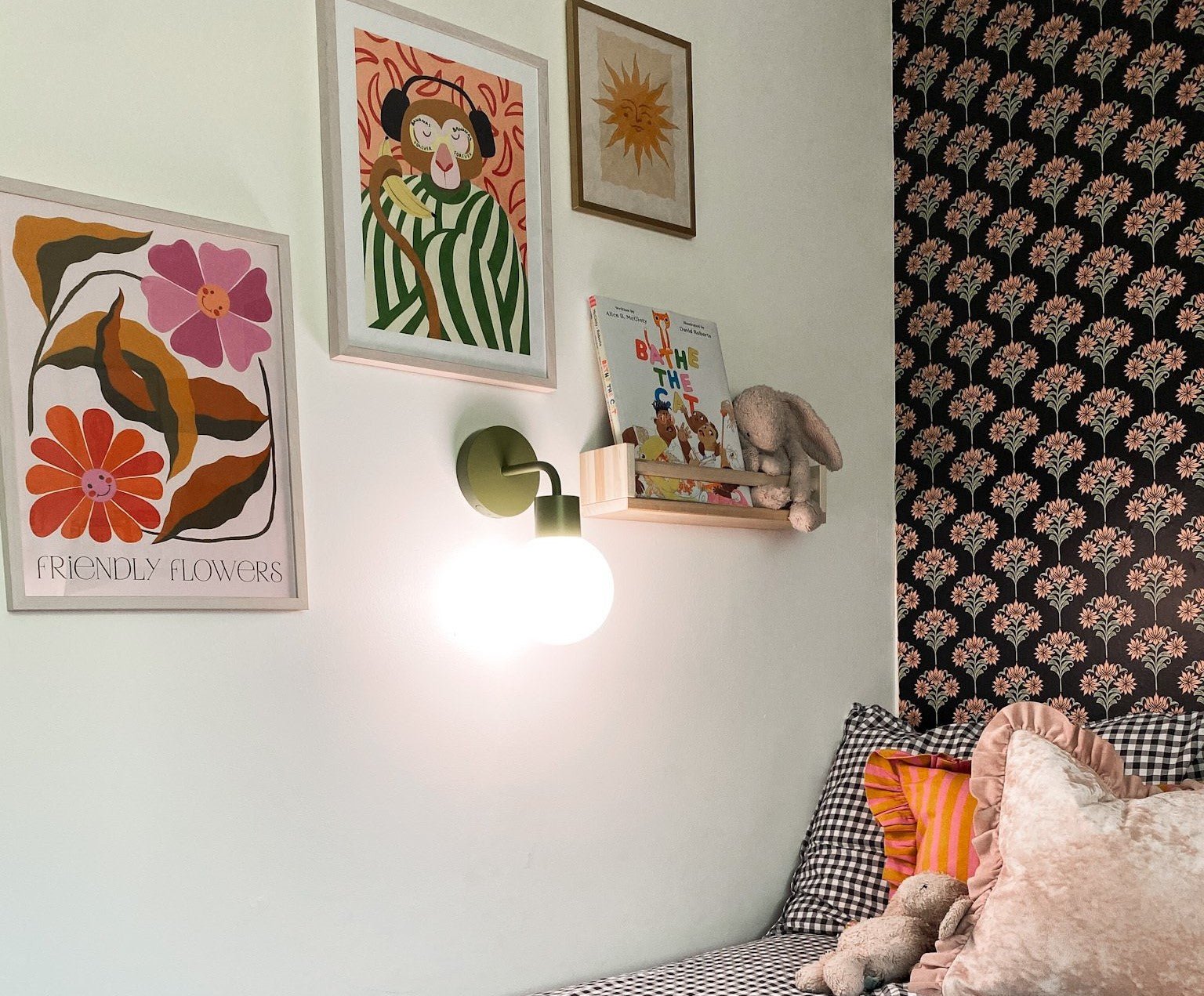 Kids bedroom decorated with kid-friendly artwork illuminated with a rechargeable wall light sconce.