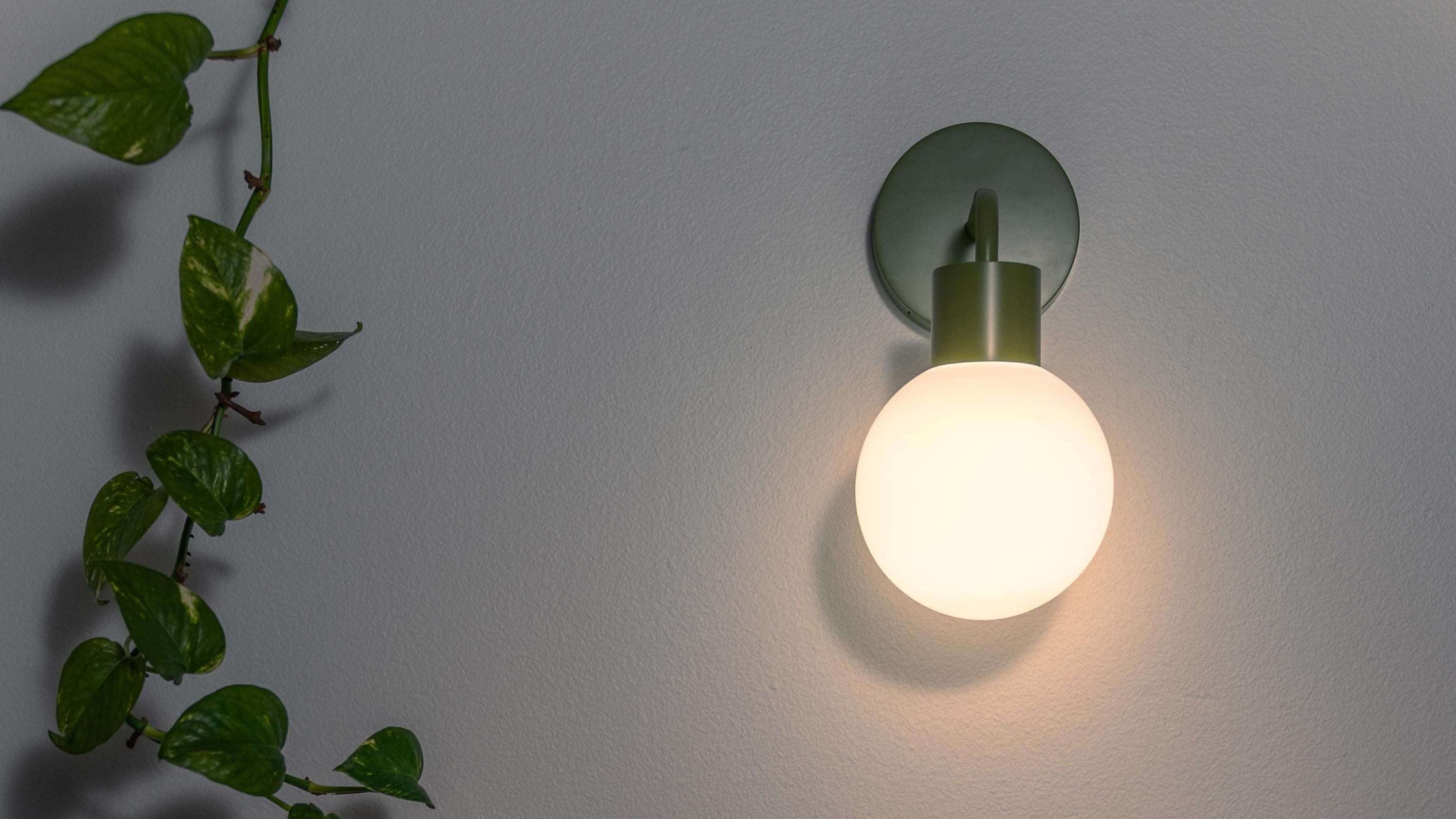 Poplight sage green wall sconce with warm light for a cozy minimalist ambience
