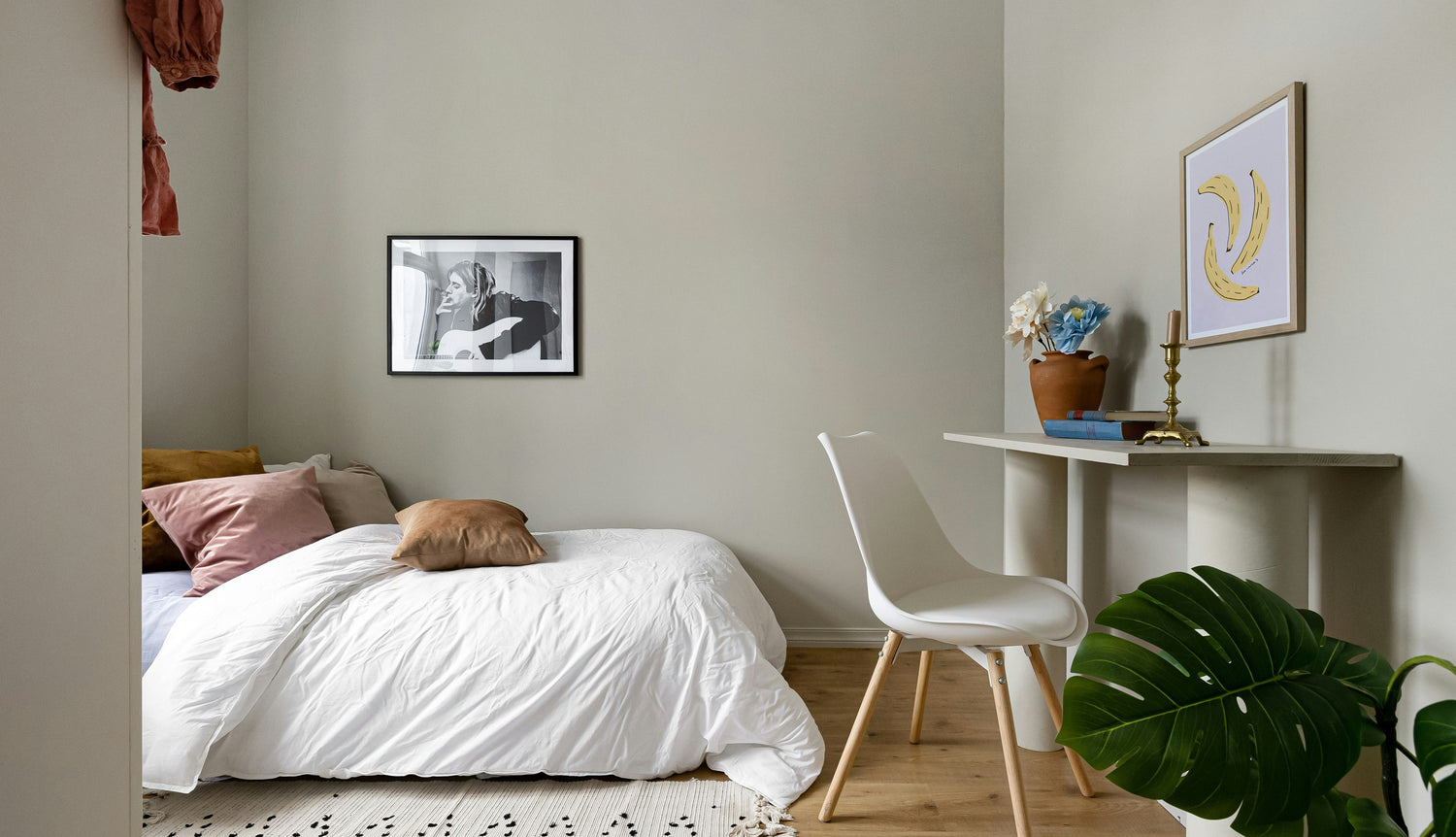 Small bedroom apartment with small table, a painting and indoor plant