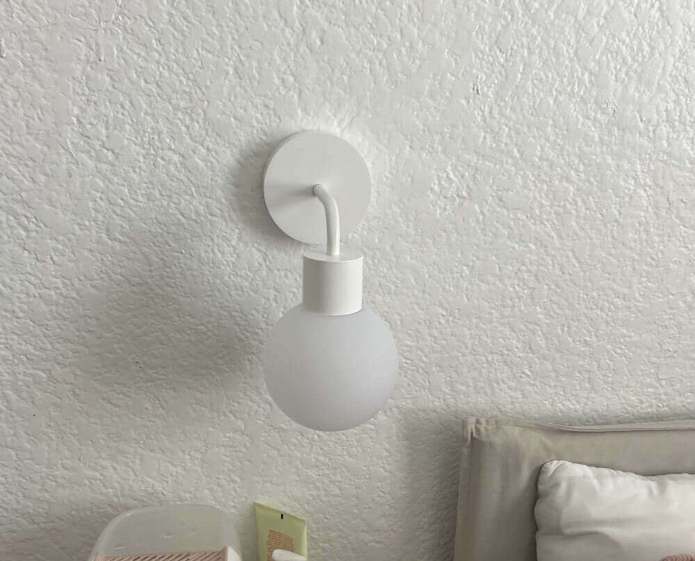 White Poplight wall sconce in a textured wall