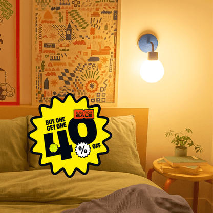 White Poplight rechargeable sconce casting an ambient light in a warm-toned bedroom with promotional badge reading &