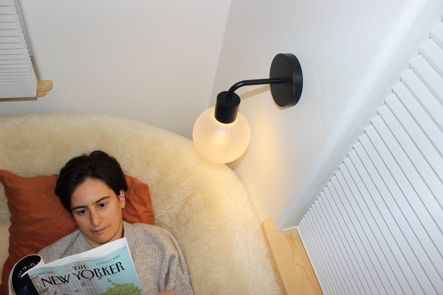 Rose reading illuminated with a matte black rechargeable wall light sconce