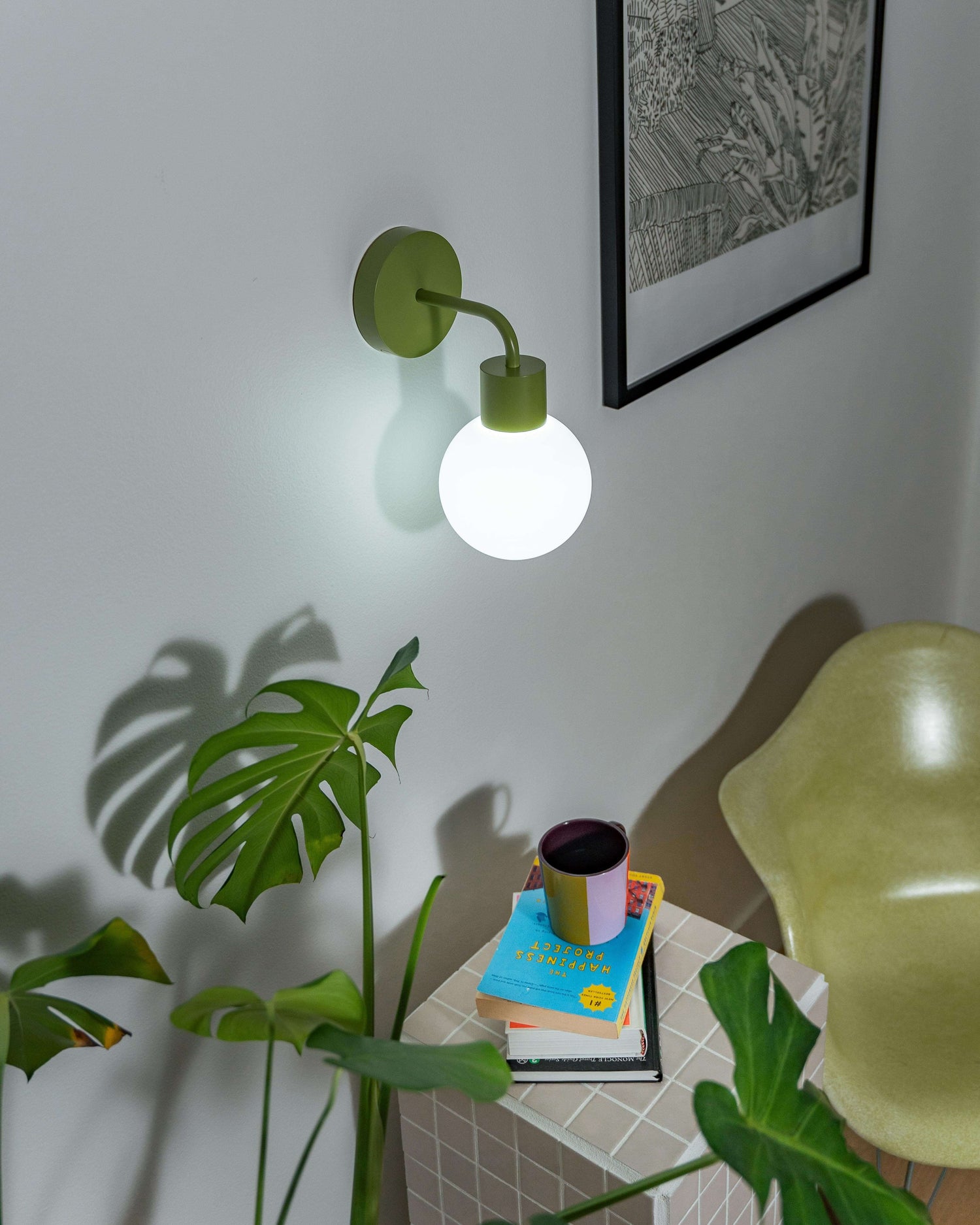 Renter-friendly rechargeable wall sconce illuminating modern room with chair, plant, and books.