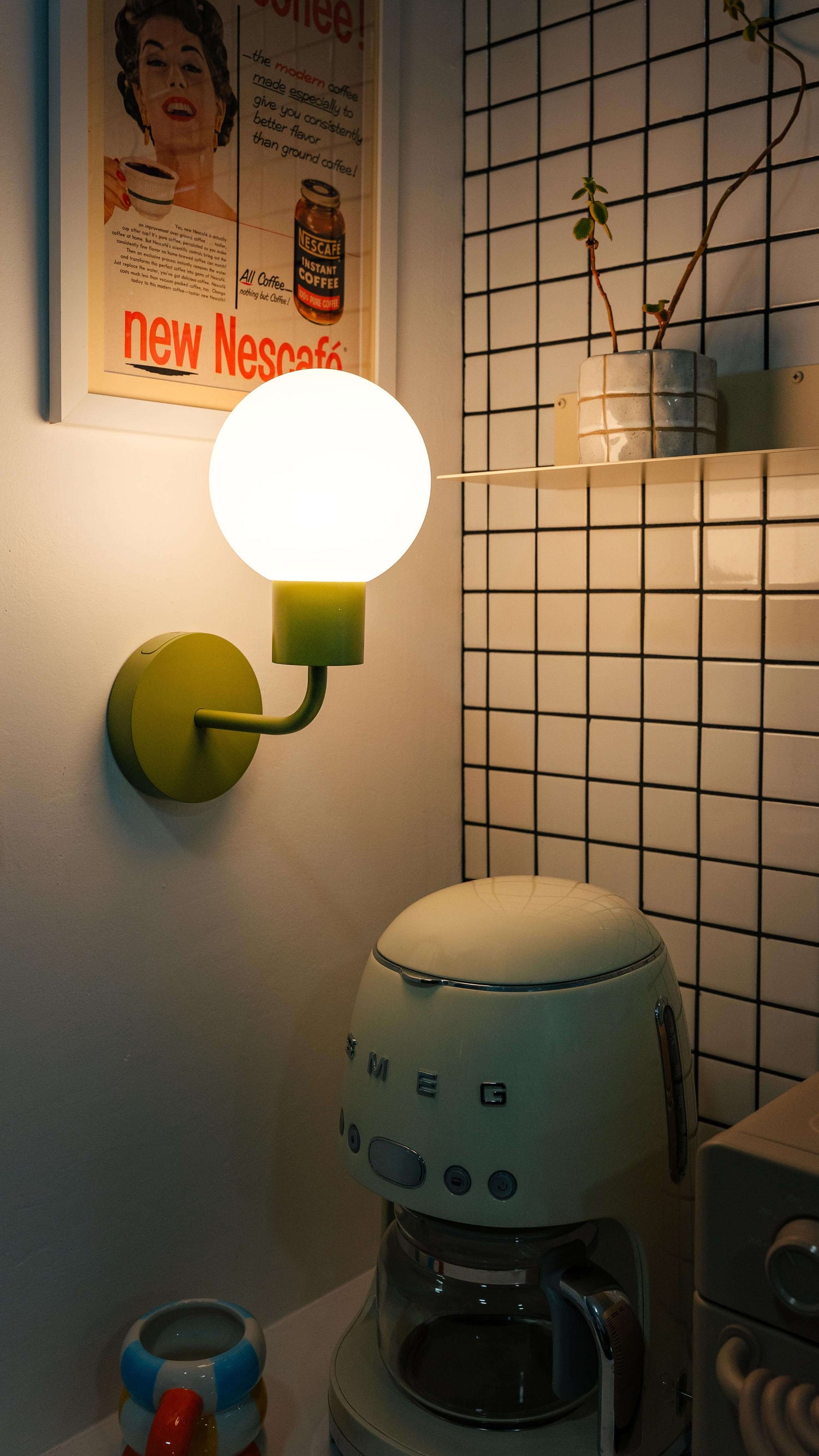 Renter-friendly rechargeable wall sconce illuminating a cozy kitchen corner with a retro coffee maker and decor.