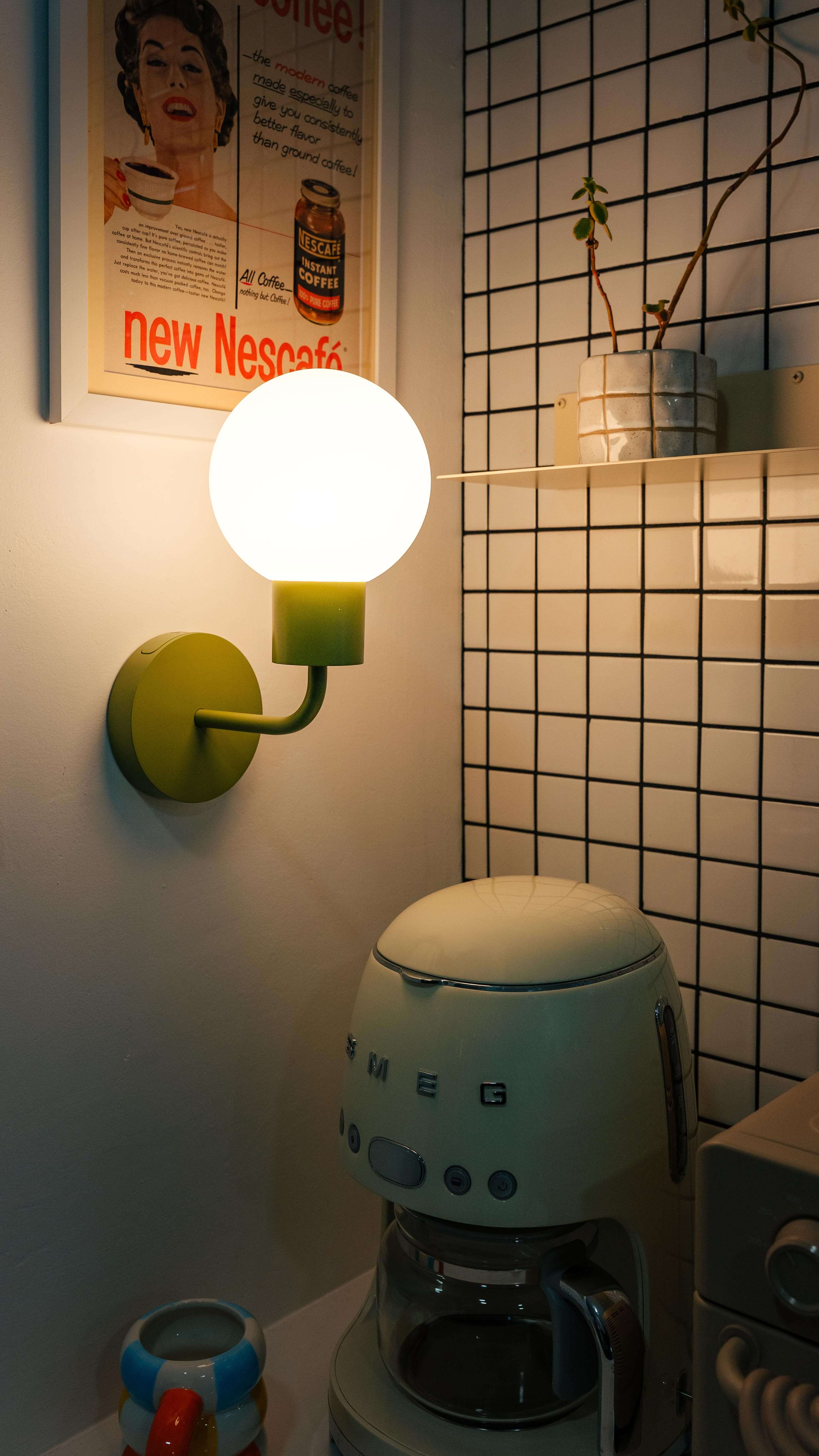 Renter-friendly rechargeable wall sconce illuminating a cozy kitchen corner with a retro coffee maker and decor.