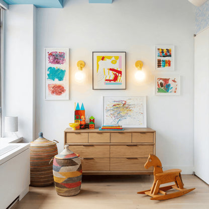 Kids play room with a wood horse toy, colorful framed art pieces and two marigold wall light sconces