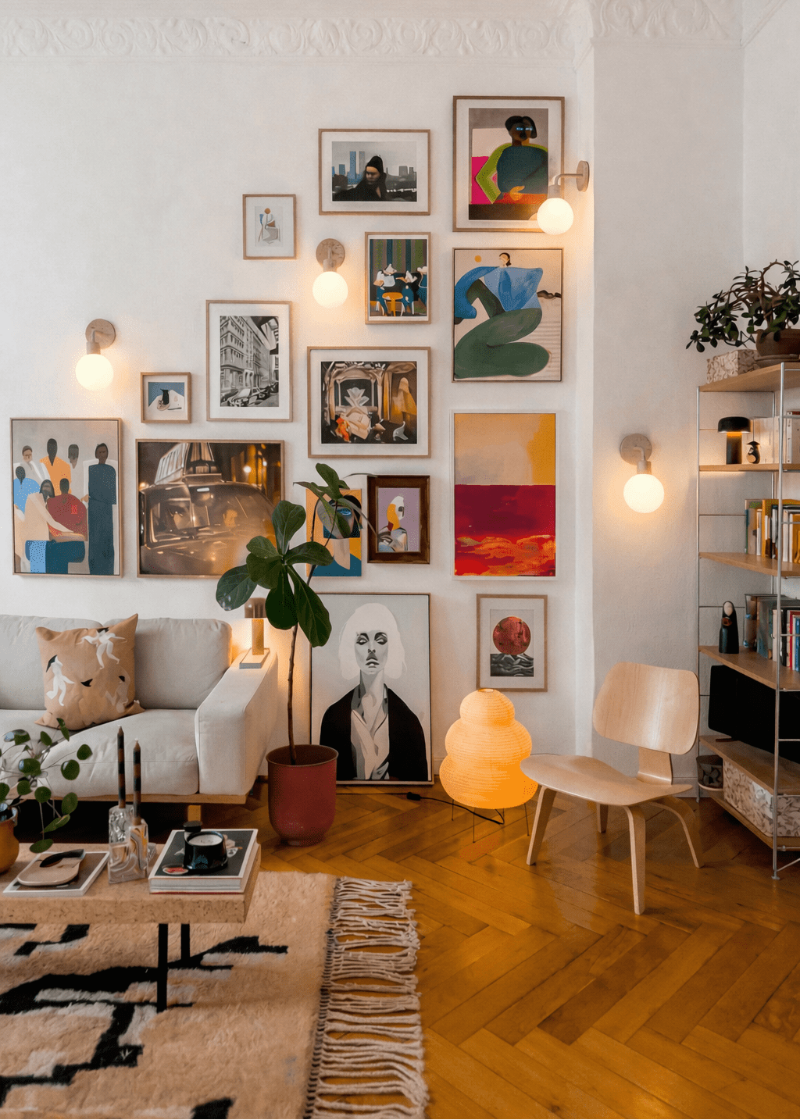 Living room with a wall of framed artwork, a sofa, and a chair.