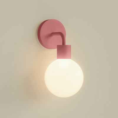 A single Dusty Rose Poplight illuminated against a beige wall