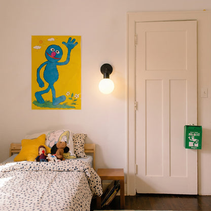 Kids room with a single wall art and a black rechargeable wall light sconce