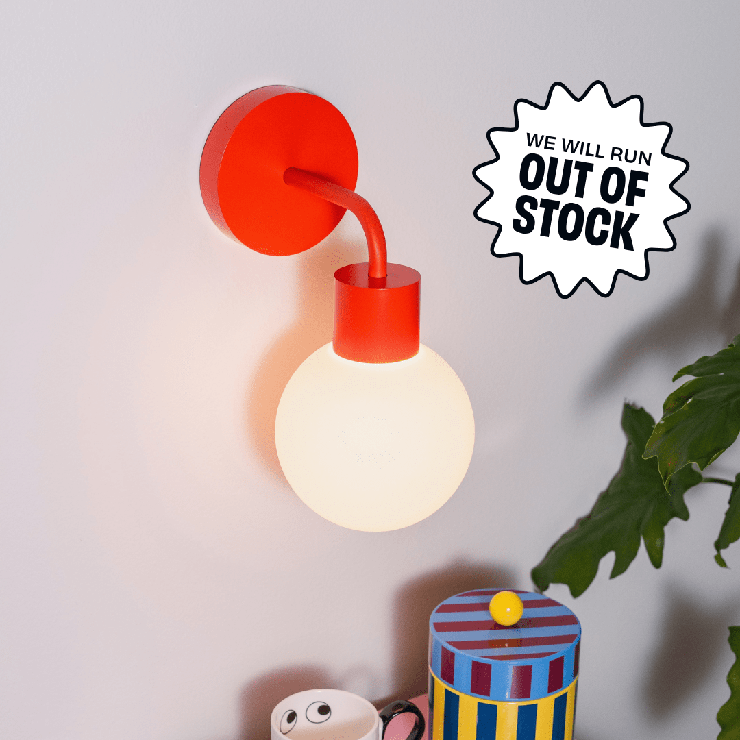 Vermillion Red Poplight mounted on a beige wall with promotional badge &