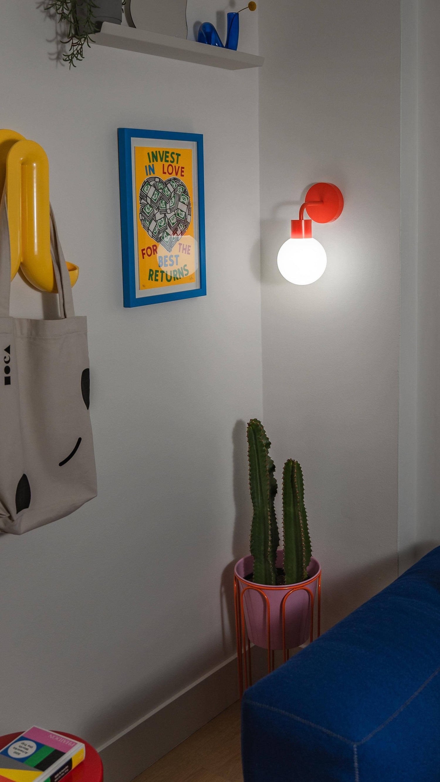 Modern renter-friendly rechargeable wall sconce illuminating a stylish living room corner with decor and cactus plant.